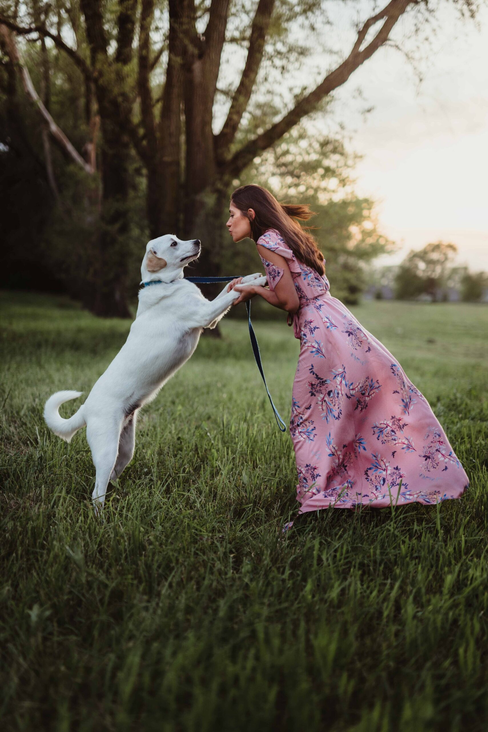 A women in a pink maxi dress and her dog