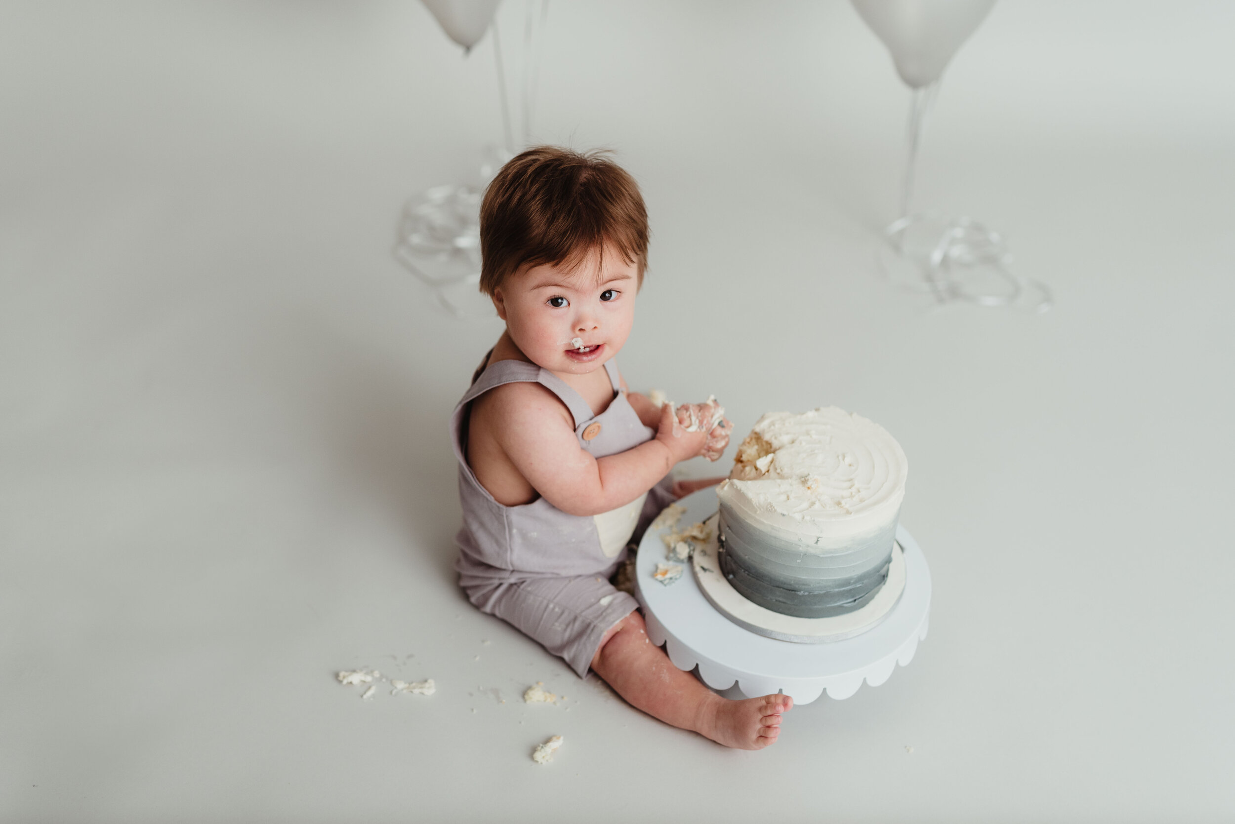 gray and cream overalls outfit for little boy's 1st birthday cake smash