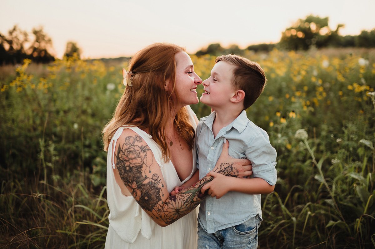 mom and young son affectionately touching noses in midwest summer field