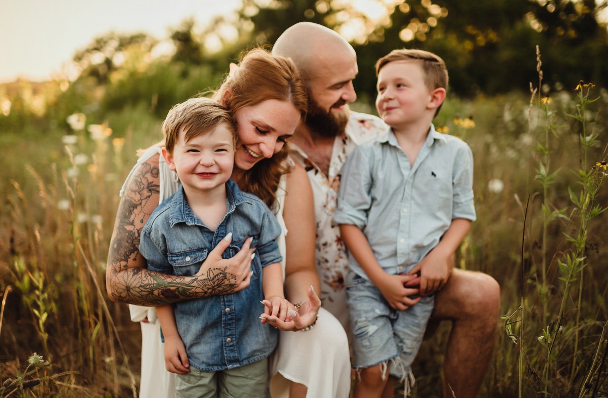 parents and two young sons in midwest summer field