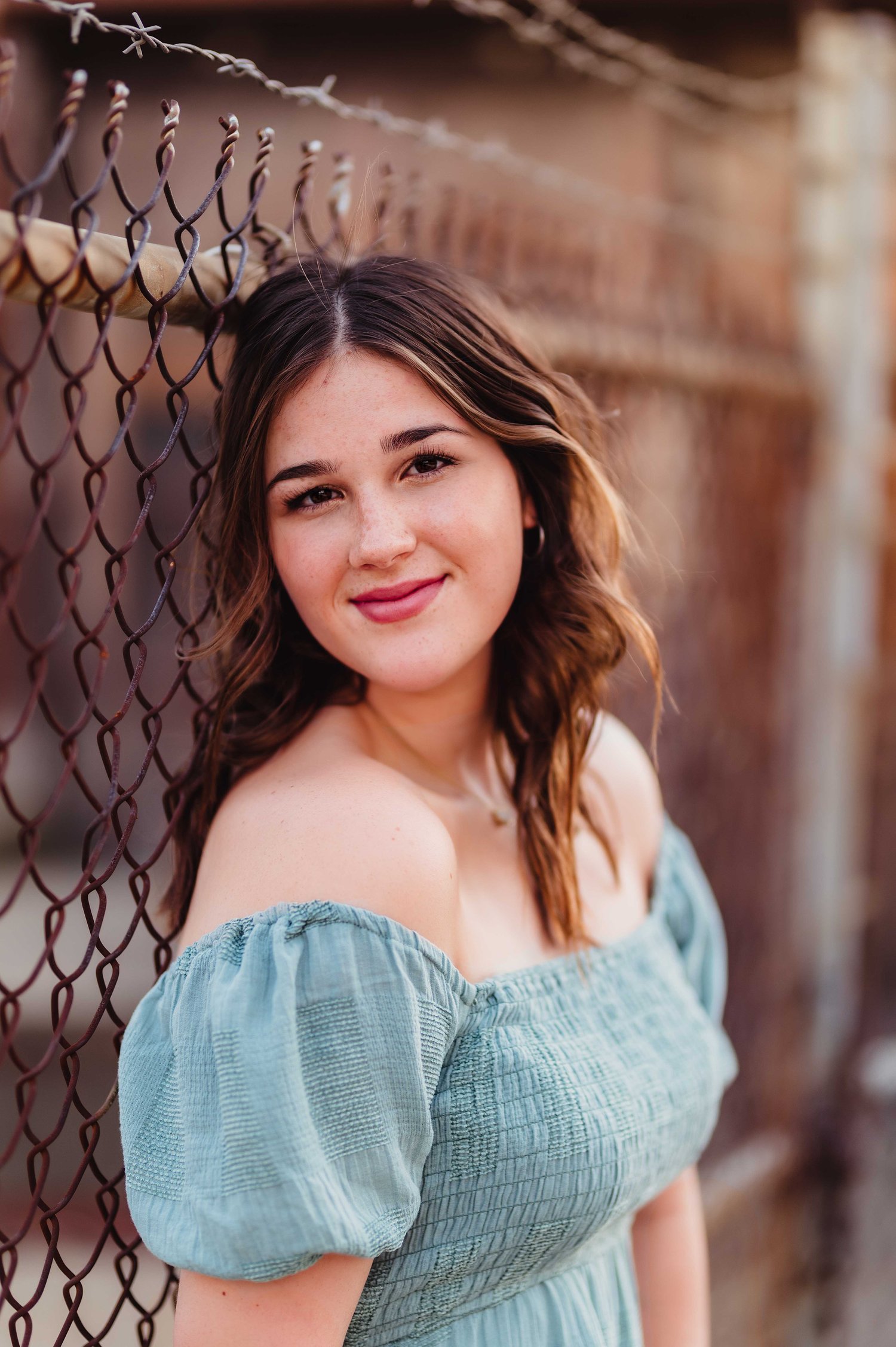 senior photography with chain link fence, Indiana senior photographer, girl's senior photo with off the shoulder dress