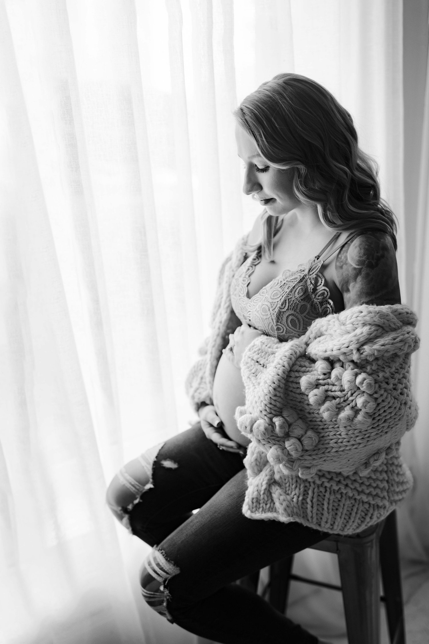 black and white boudoir maternity session with sweater and jeans