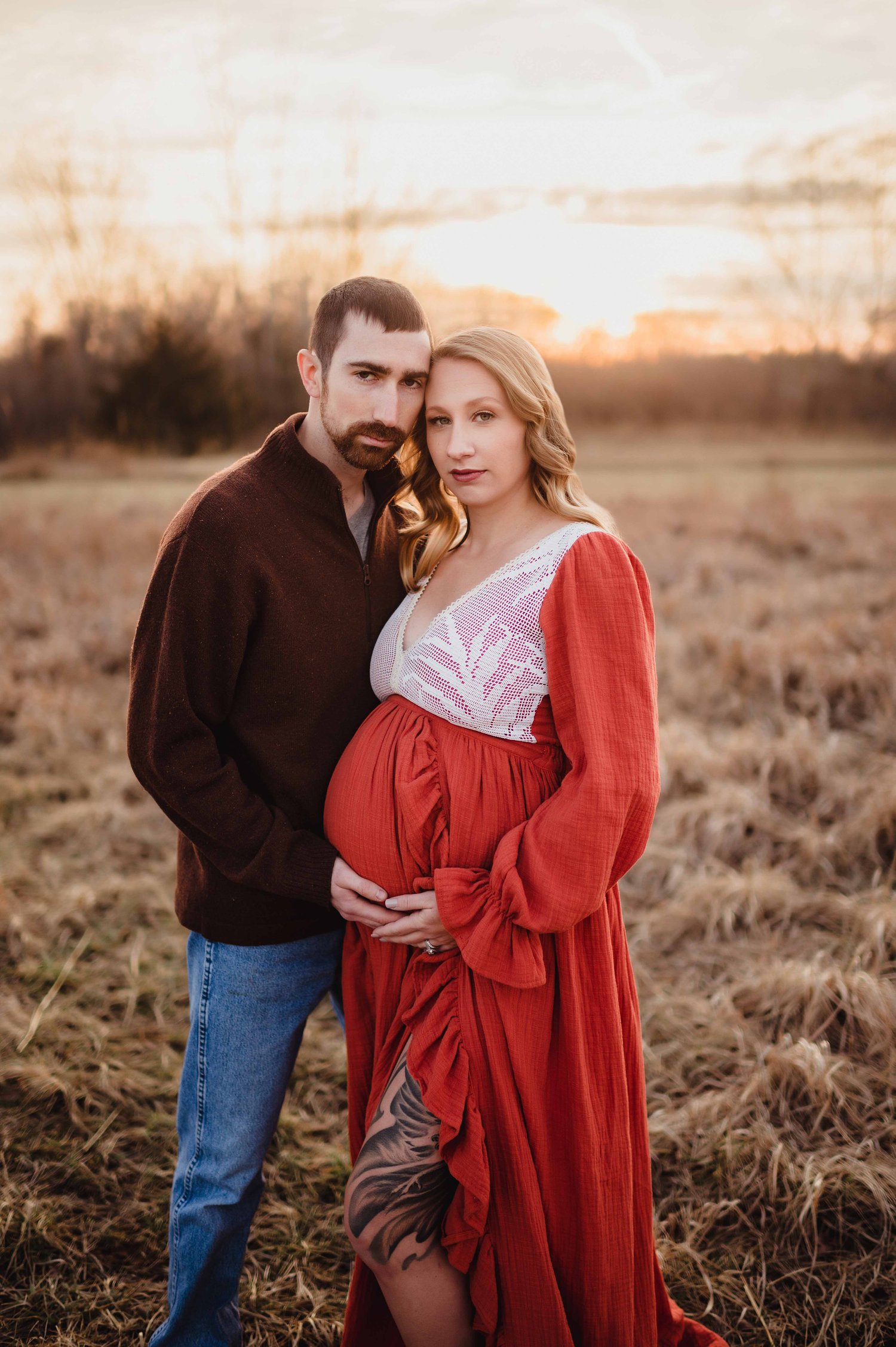sunset maternity session with rust colored dress in field
