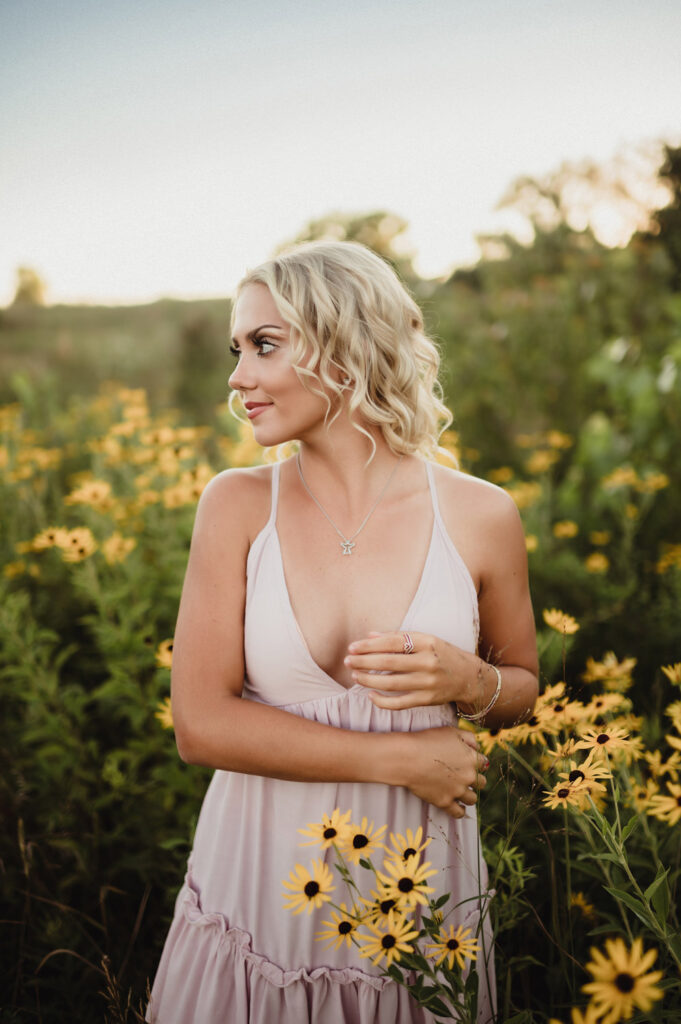 Capture the Real You: A Senior Photo Session Experience in Greensboro-senior photo session in Greensboro Senior portraits in Greensboro NC with a natural field setting. Blonde high school senior in a flowy dress surrounded by black-eyed Susans.