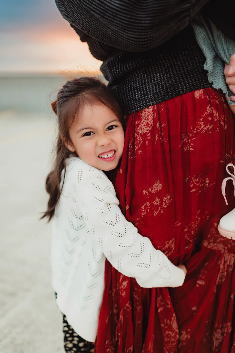 young daugher hugging mom's legs