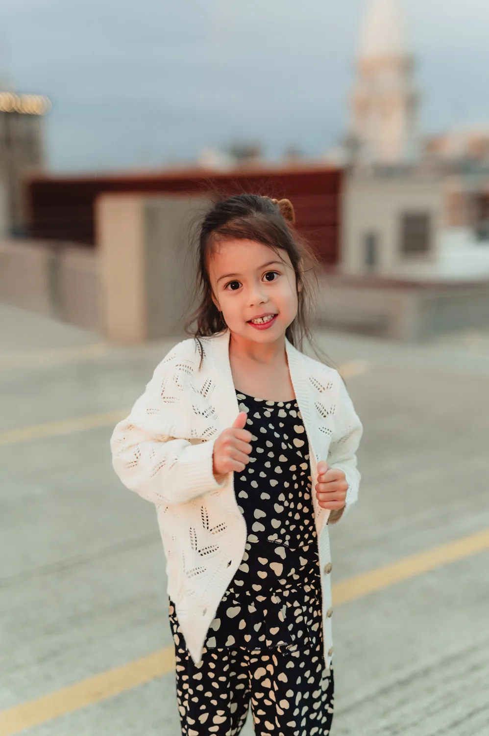 toddler girl standing in parking lot