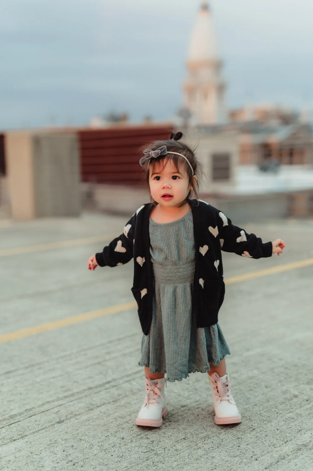 toddler girl standing with city view in background