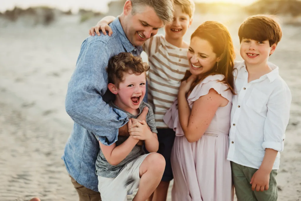 50 Must-Try Family Poses: Inside the KMP Posing Deck That Can Transform Your Sessions Family laughing together during a lifestyle beach photography session, example from the KMP Family Posing Guide