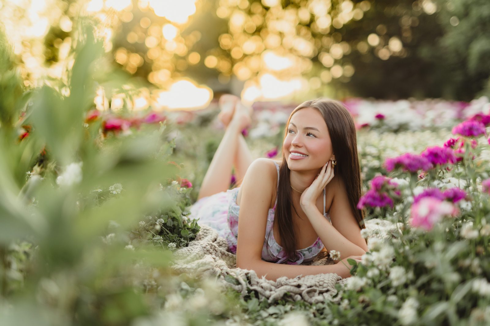 🌼 A Wildflower Field at Golden Hour: Genna’s Senior Session | Greensboro Senior Photographer-Greensboro Senior Photographer High school senior lying in a flower field, smiling and relaxed during spring senior session by Greensboro senior photographer.