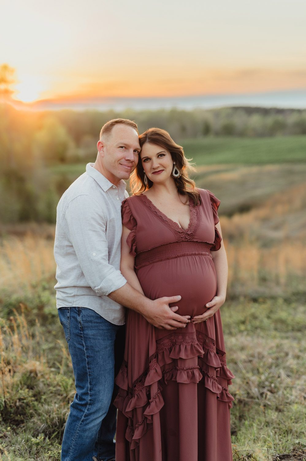 Expecting Baby #2: Golden Hour Maternity Photos in Greensboro-Greensboro maternity photos Expecting couple embracing at sunset during a maternity photo session near Greensboro, NC