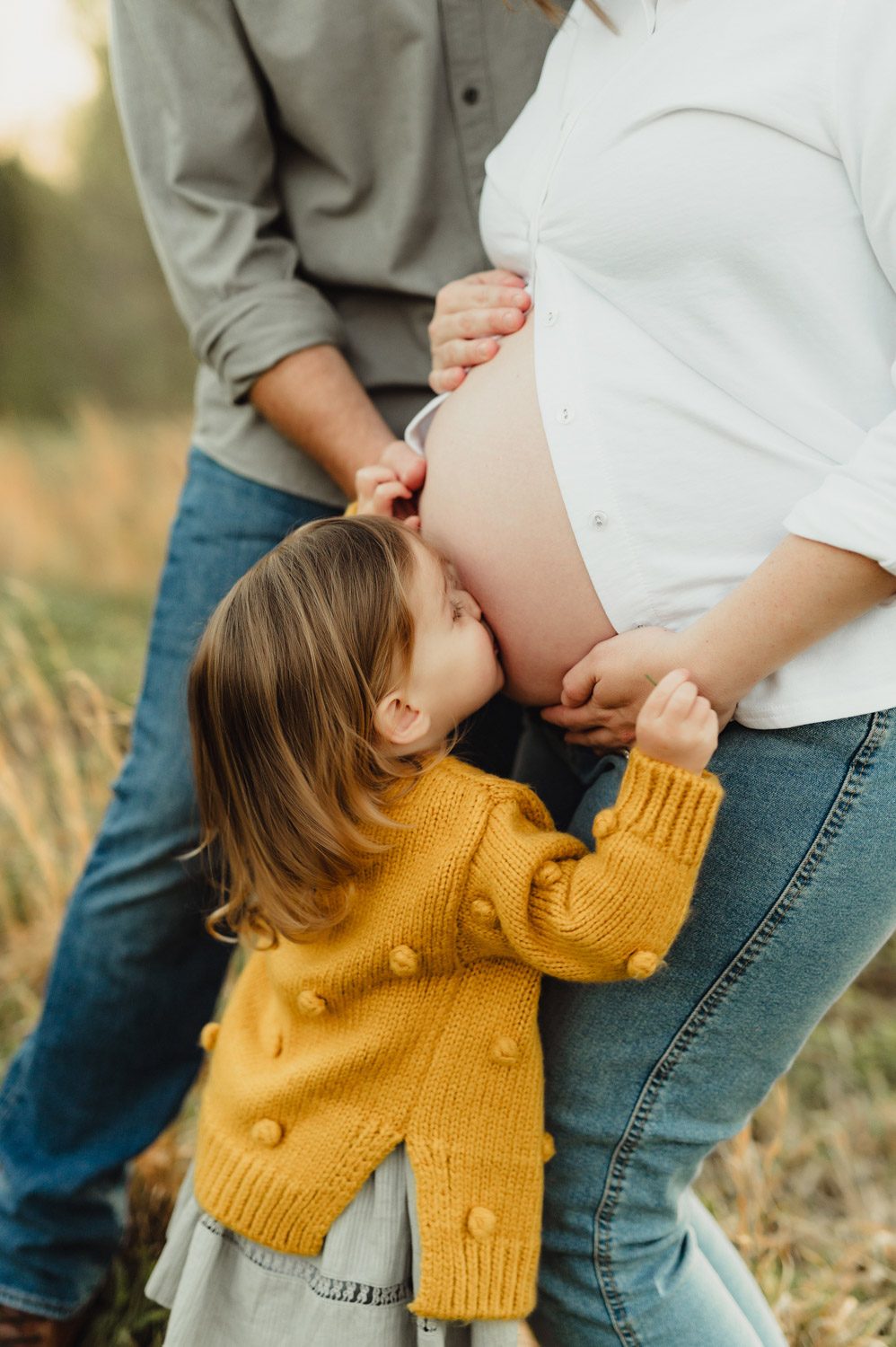 Expecting Baby #2: Golden Hour Maternity Photos in Greensboro-Greensboro maternity photos Toddler in mustard sweater kissing her mama’s pregnant belly during a Greensboro maternity photos
