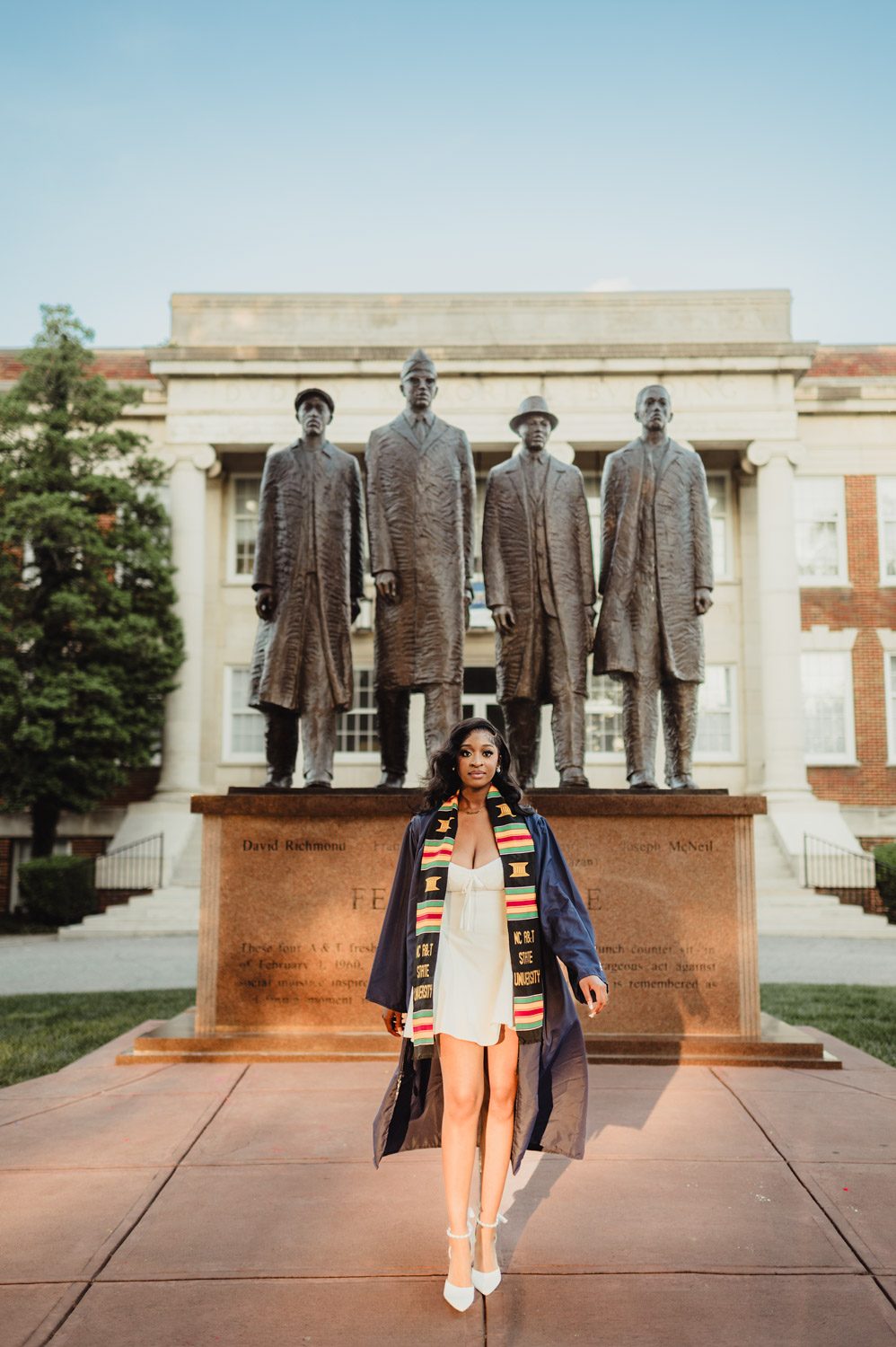 NC A&T Graduation Photos - Victoria’s Golden Hour Session-NC A&T graduation photos NC A&T graduation photo of a young woman in graduation gown standing in front of the February One Monument honoring the A&T Four civil rights leaders.