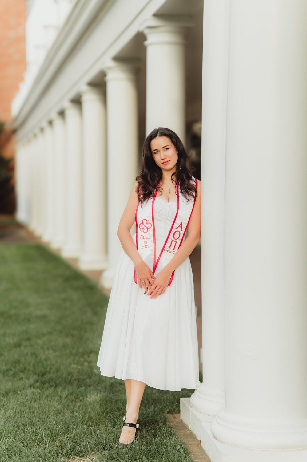Graduation Photos at Elon University: Celebrating Amelia's Big Moment-Graduation Photos at Elon University Amelia poses in her white graduation dress and sorority stole among the white columns of the Colonnades at Elon University, a classic senior photo location on campus.