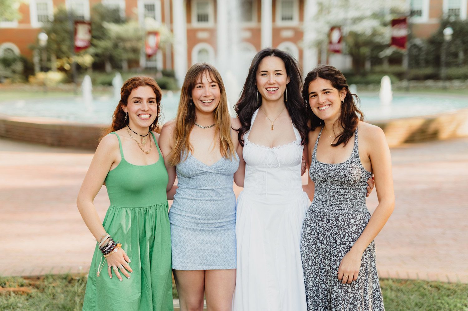 Graduation Photos at Elon University: Celebrating Amelia's Big Moment-Graduation Photos at Elon University Amelia poses with three friends in front of Fonville Fountain at Elon University, all smiling and dressed in spring outfits during her graduation photo session.