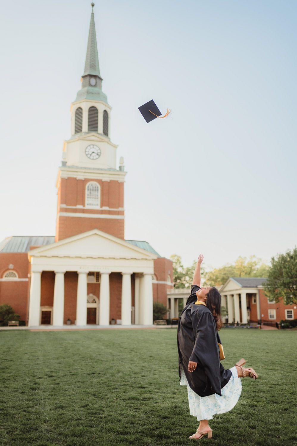 Wake Forest Graduation Photos | Celebrating Aris’s Master’s Degree-Wake Forest graduation photos Wake Forest graduate throwing cap in front of Wait Chapel to celebrate master’s degree completion