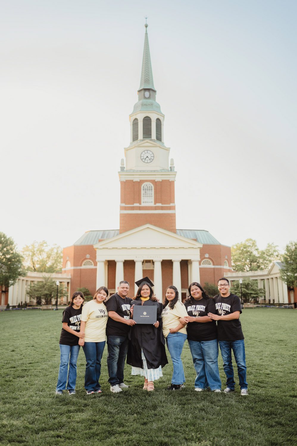 Wake Forest Graduation Photos | Celebrating Aris’s Master’s Degree-Wake Forest graduation photos Wake Forest graduation family photo in front of Wait Chapel, celebrating a master’s degree graduate