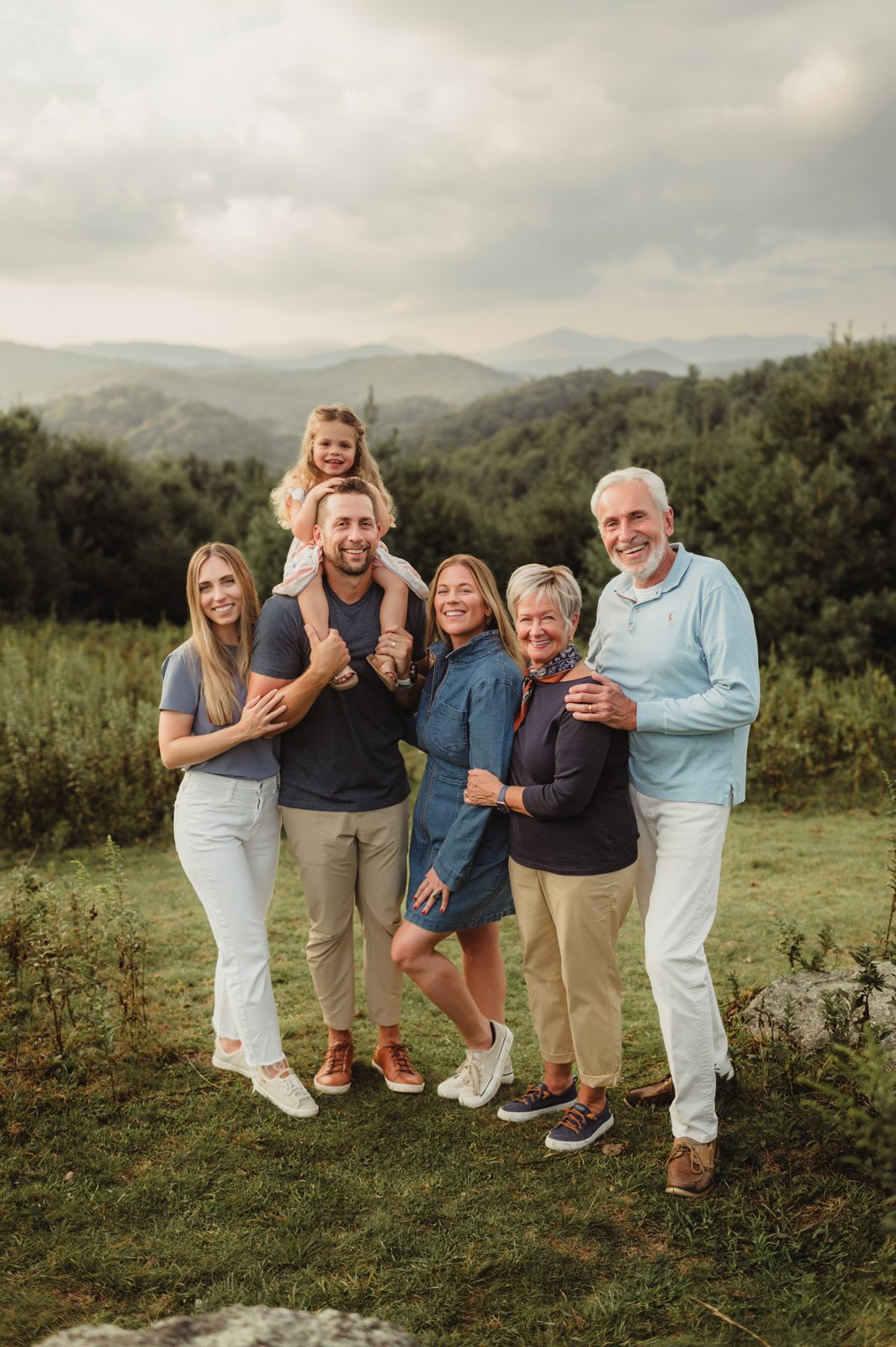 Capturing Generations: Extended Family Photos in Blowing Rock-extended family photos in Blowing Rock Three-generation family smiling together with mountain views in the background during an extended family photo session in Blowing Rock, North Carolina.