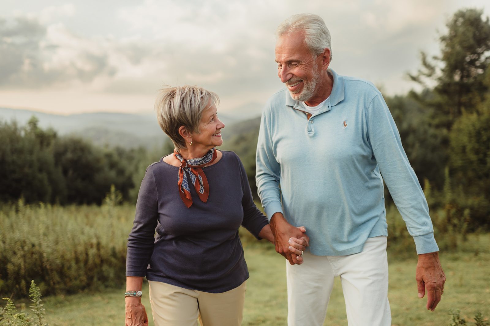 Capturing Generations: Extended Family Photos in Blowing Rock-extended family photos in Blowing Rock Smiling grandparents holding hands during a sunset family photo session in the Blue Ridge Mountains near Blowing Rock, NC.
