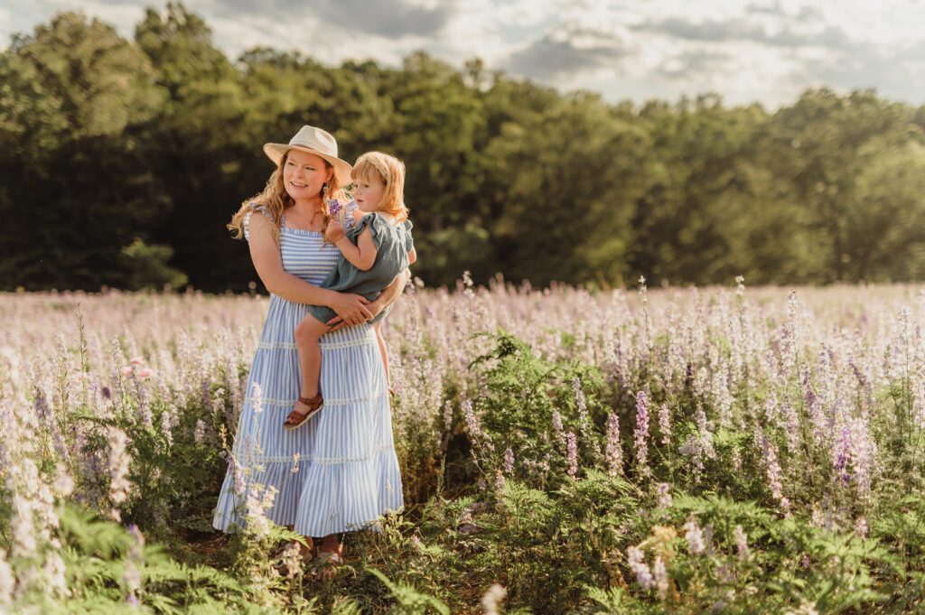 In Full Bloom: Mother Daughter Photos in a Field of Wildflowers-mother daughter photos Mother and daughter standing in a field of wildflowers during golden hour – mother daughter photos in Greensboro NC