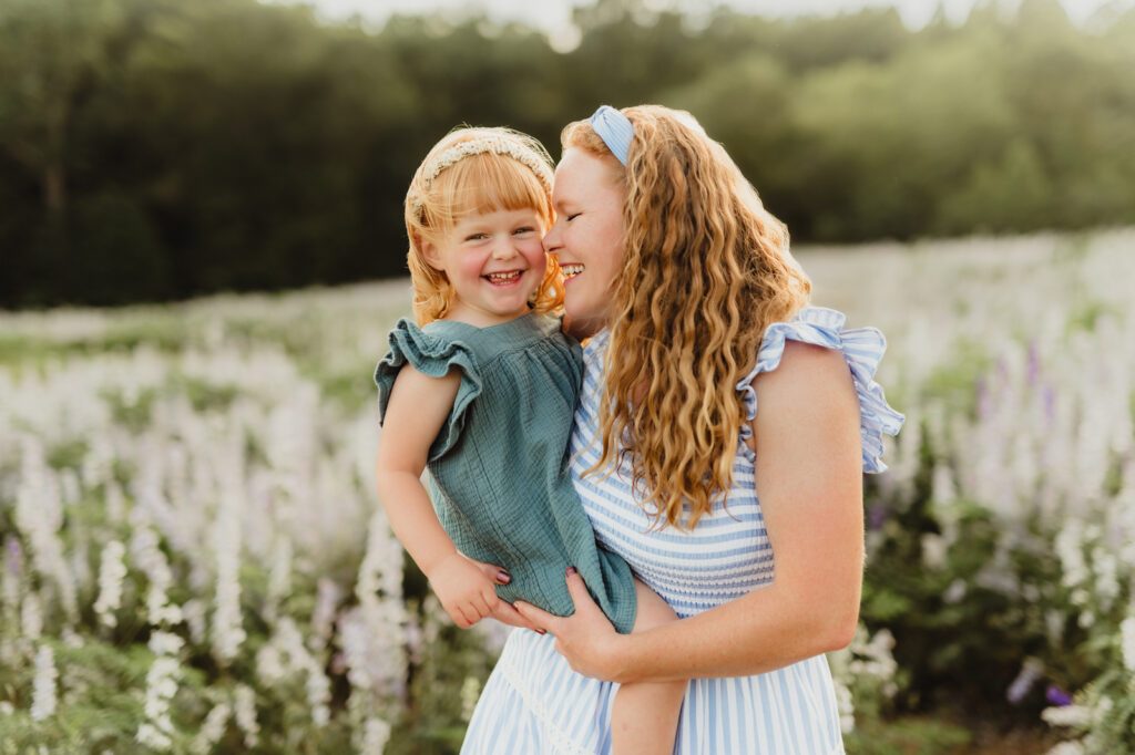 50 Must-Try Family Poses: Inside the KMP Posing Deck That Can Transform Your Sessions Mother holding her daughter and laughing together in a meadow, lifestyle family pose example from the KMP Family Posing Guide