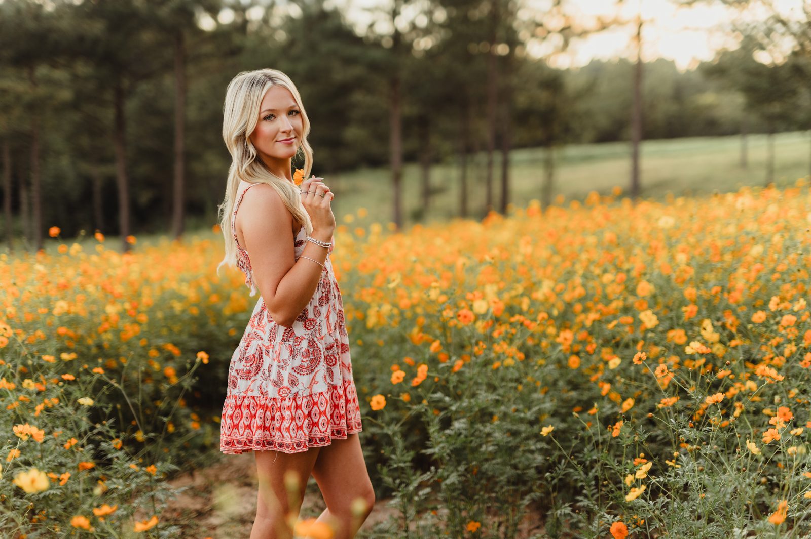 Senior picture pose idea – over-the-shoulder look in flower field, Triad NC senior photography