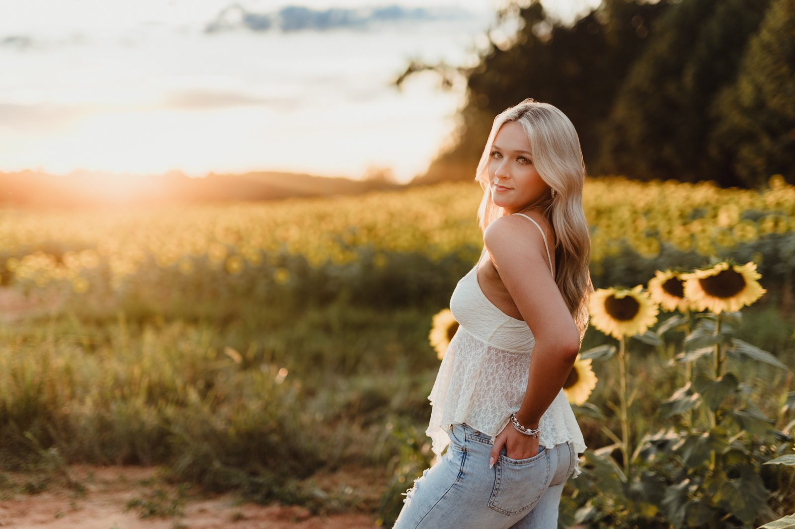 High Point senior portraits – natural standing pose in sunflower field during golden hour