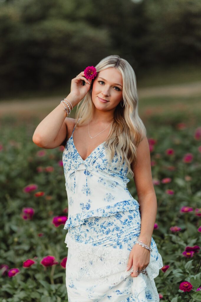 Senior photo pose inspiration – creative portrait with flower prop in Triad NC wildflower field