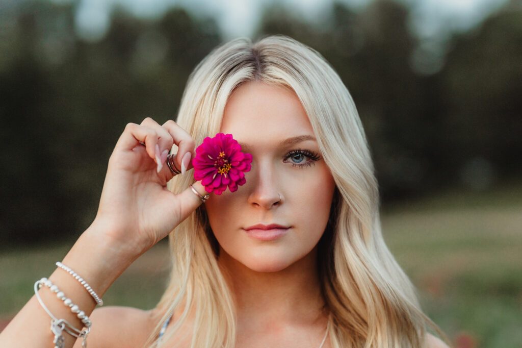 Greensboro NC senior portraits – fun and creative close-up pose with flower accent