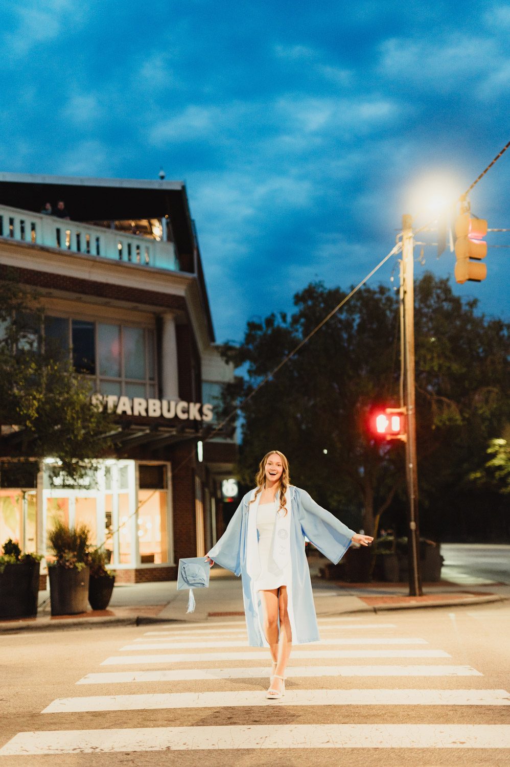 These UNC Graduation Photo Spots Still Feel Like Home-UNC Graduation Photos Graduation photo of UNC student walking on Franklin Street in downtown Chapel Hill