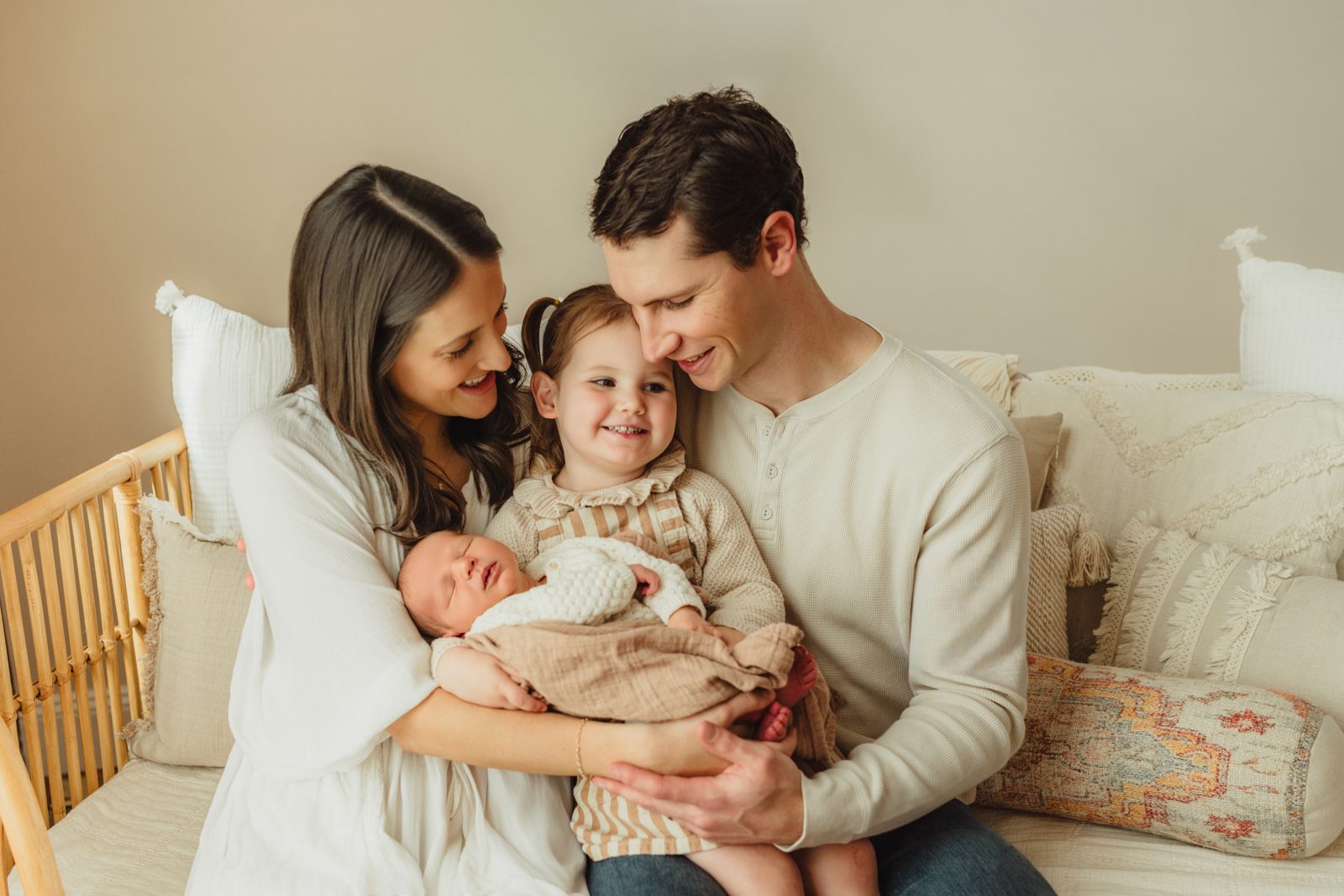 Greensboro newborn photographer captures family leaning in together over newborn baby boy