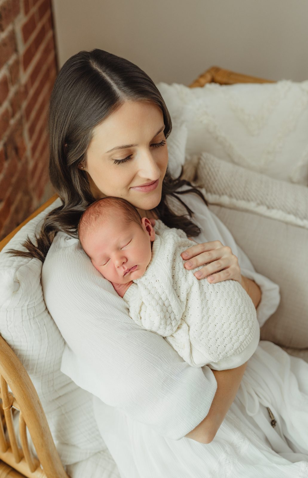 Mom smiling down at newborn baby boy during Greensboro newborn session at Revolution Mill
