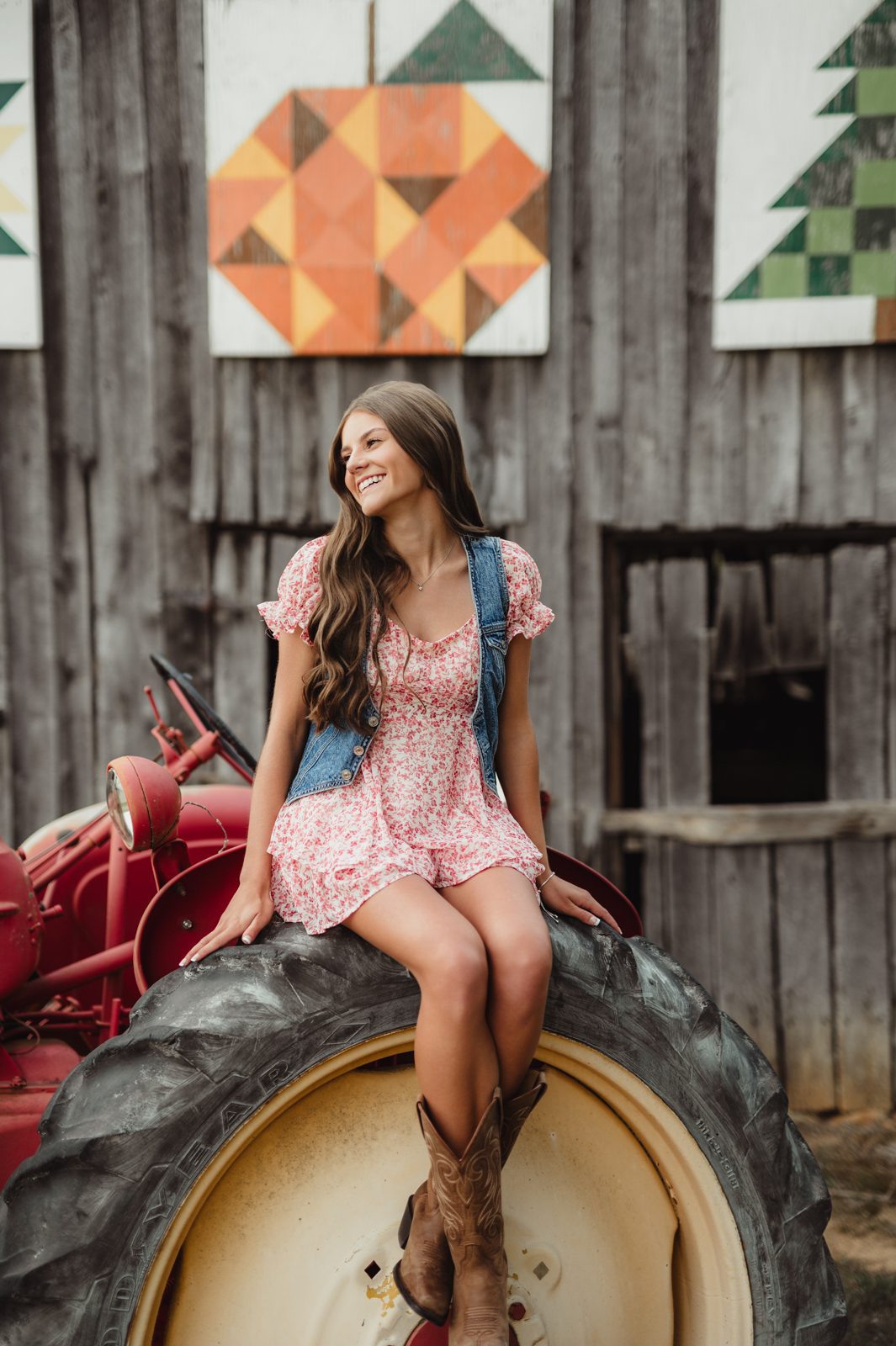 Senior girl sitting on vintage tractor tire during Greensboro senior session