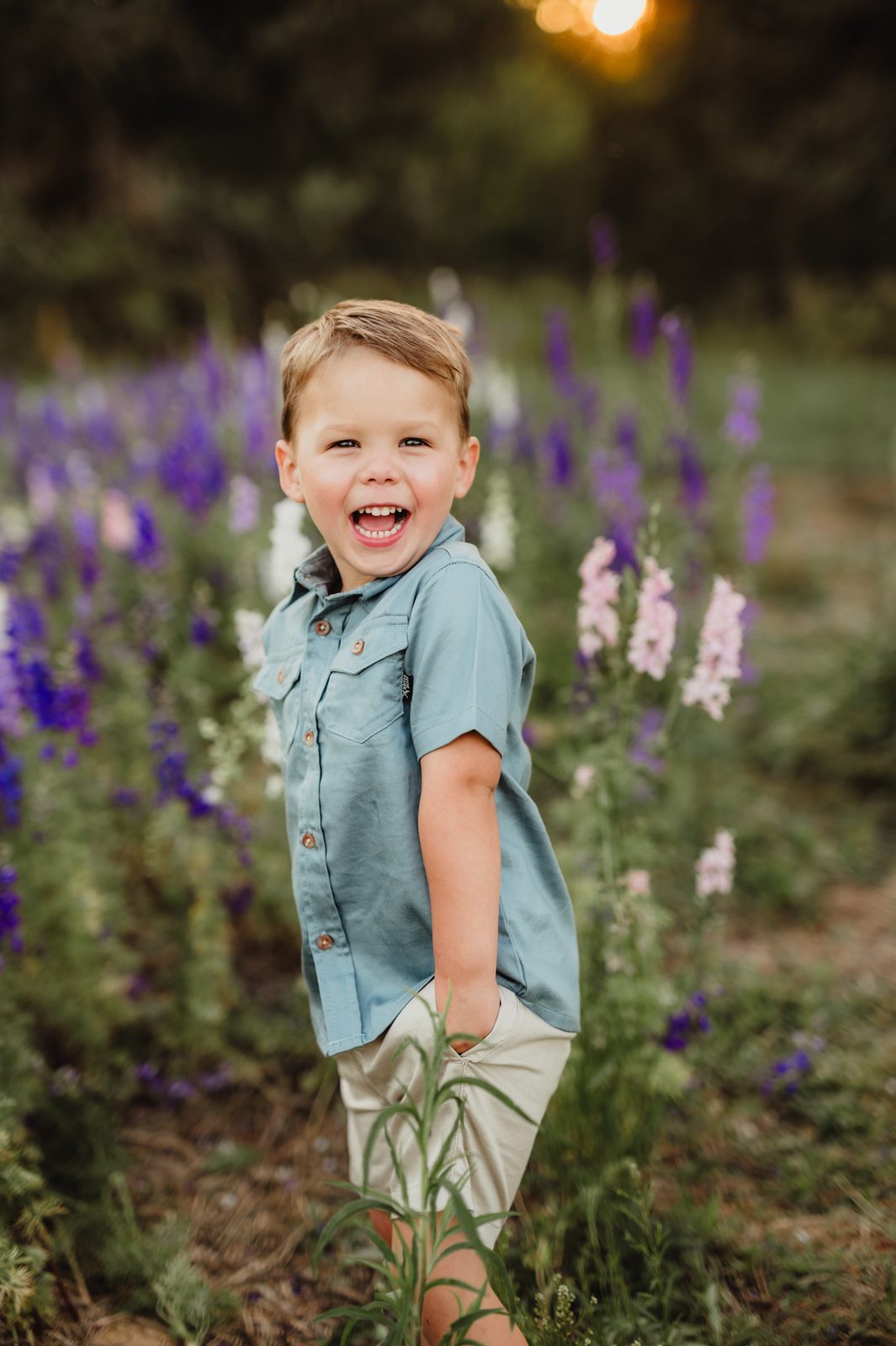 Worth the Drive: A Wake County Wildflower Session with the McInnes Family A young boy in a denim shirt laughing in a field of purple and white larkspur
